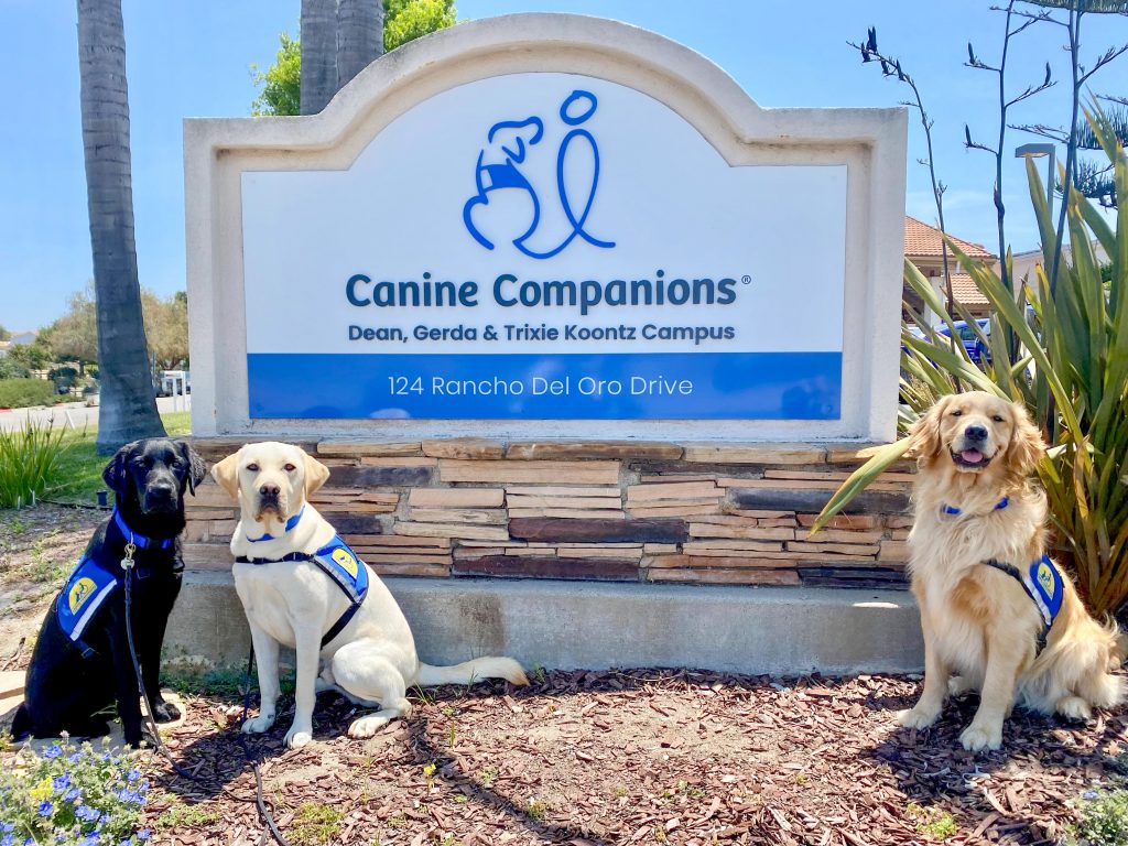 Canine Companions Southwest Region campus sign with three dogs in professional training