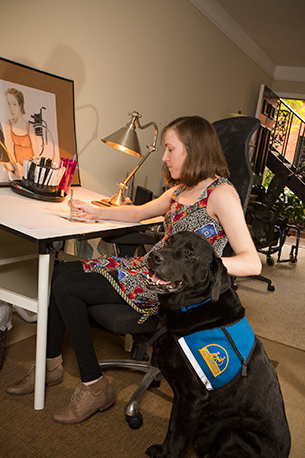 person sitting with Canine Companions service dog