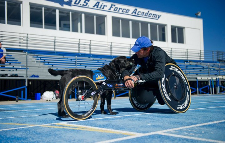 person in athletic wheelchair and a Canine Companions service dog