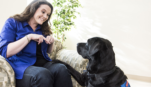 person doing sign language with a Canine Companions service dog