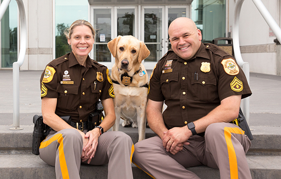two police next to Canine Companions service dog