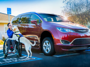 person and Canine Companions service dog next to Chrysler Pacifica