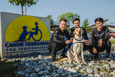 three people and a Canine Companions service dog