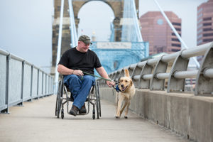 person in wheelchair next to Canine Companions service dog