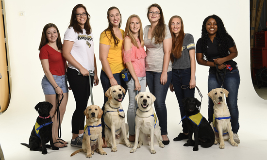 Group of Collegiate Puppy Raisers and the Canine Companions puppies they are raising