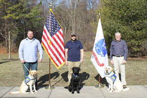 three people with Canine Companions service dogs