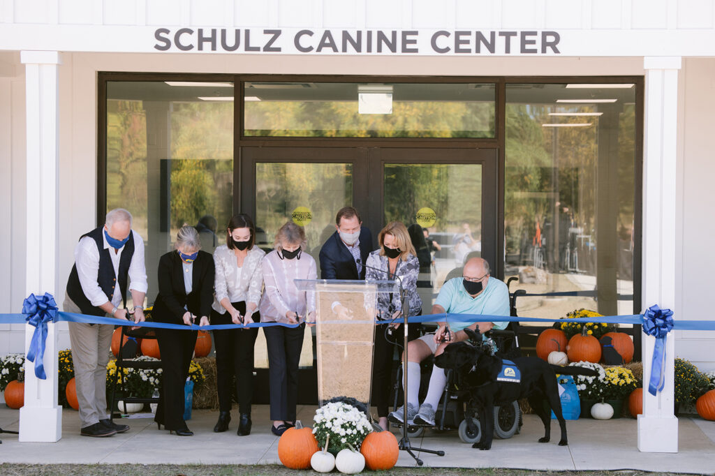 group of people cutting a ribbon at the Schulz Canine Center