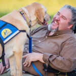 man with Canine Companions service dog face to face