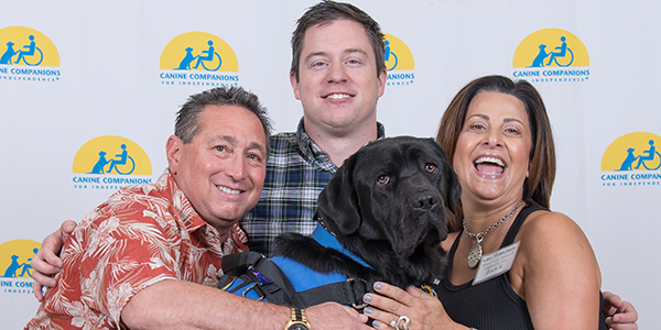 three people with Canine Companions service dog