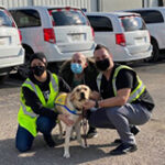 three people squatting down with Canine Companions service dog