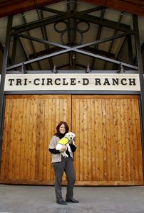 woman holding a puppy at tri-circle-d-ranch