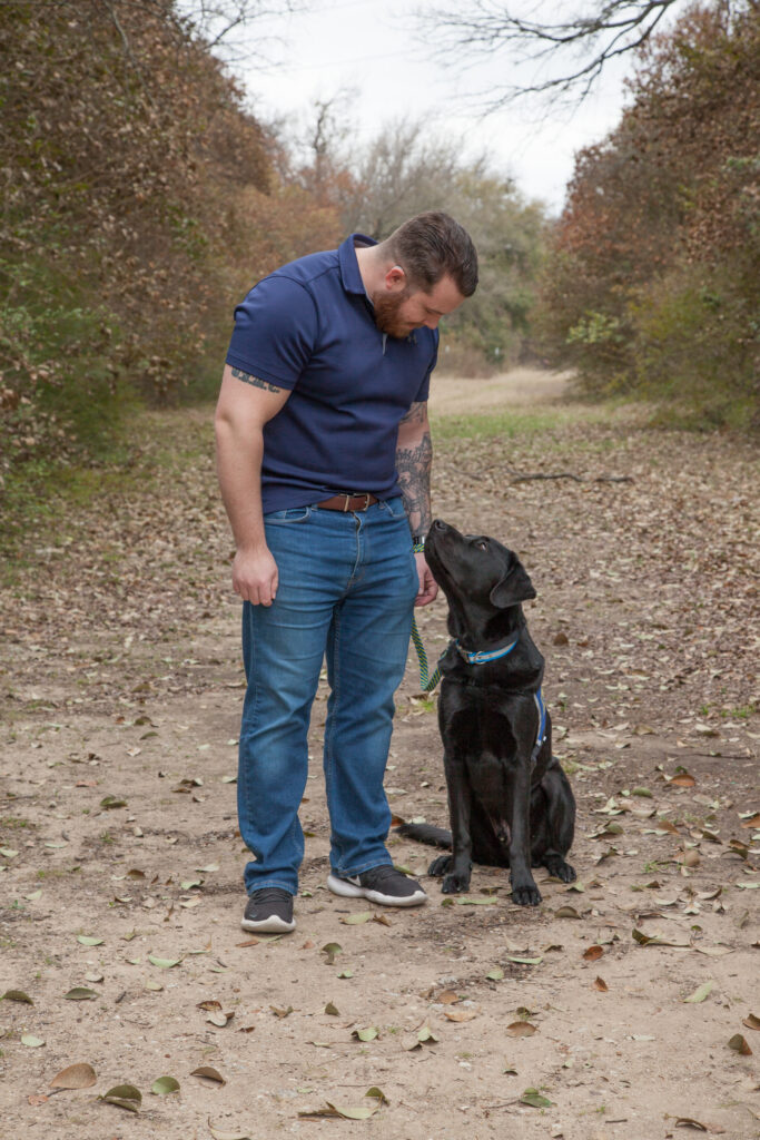 Canine Companions graduate looking at service dog by his side