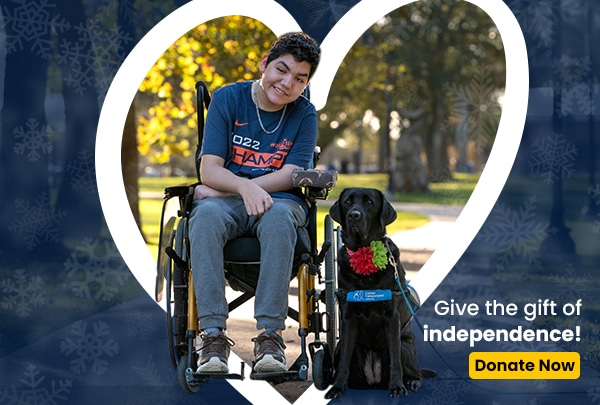 A smiling boy in a wheelchair next to a black lab service dog in a blue service vest. The text reads Give the gift of independence! Donate now