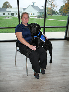 Young woman with facility dog next to her