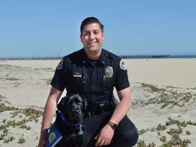 Lieutenant Nicholas and Facility Dog Yosa on the beach
