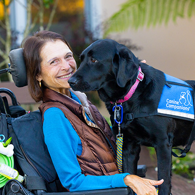 Image of Jeanette in a wheelchair with service dog Fiji in her lap