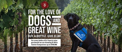 Black lab in blue service vest sits in a vineyard, with the text For The Love Of Dogs And Great Wine on the image