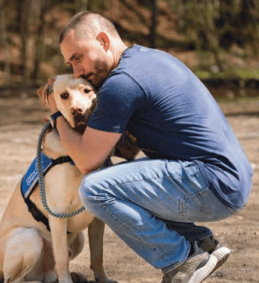 Veteran hugging his service dog Dixon