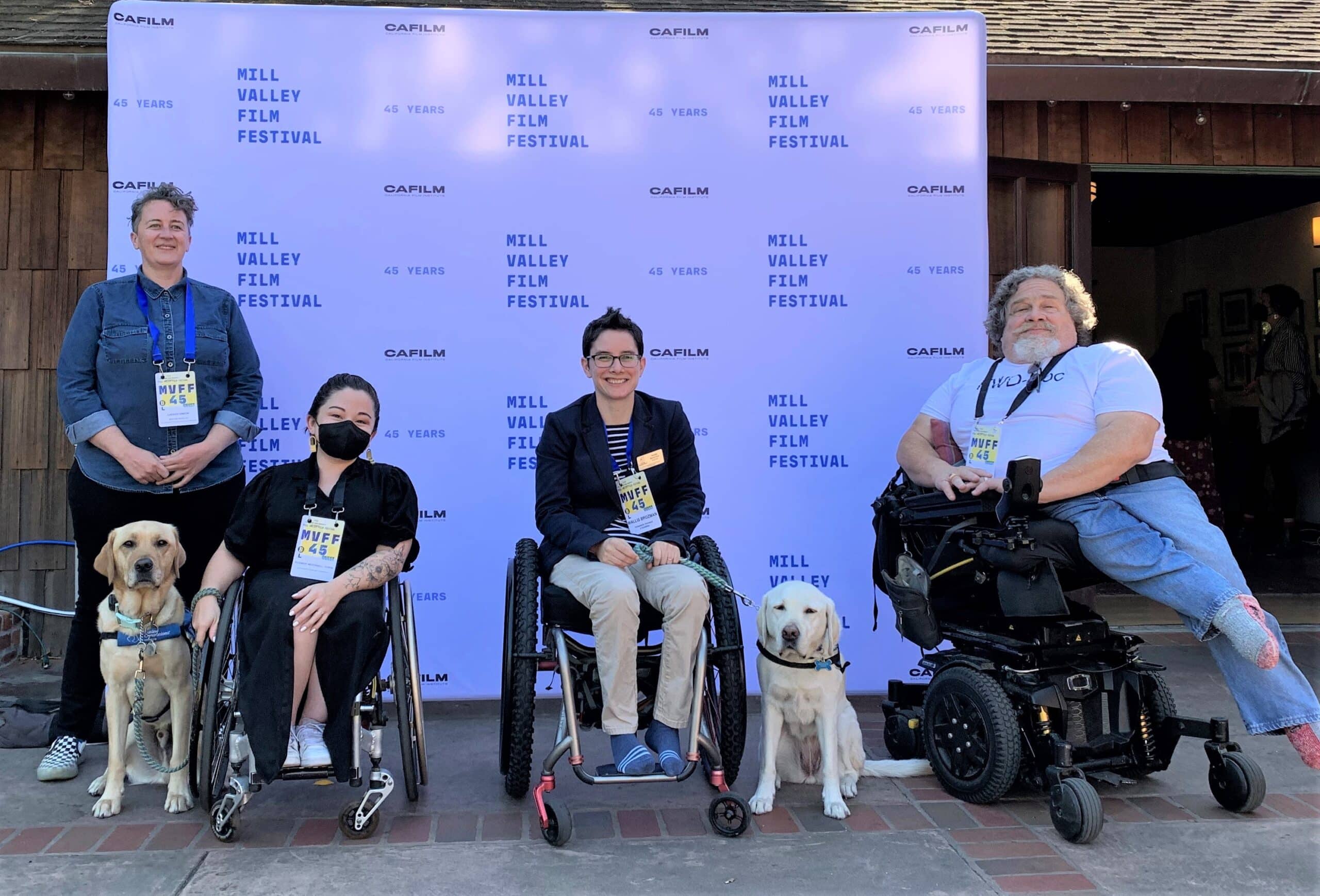 A group of people in wheelchairs with service dogs at a film festival