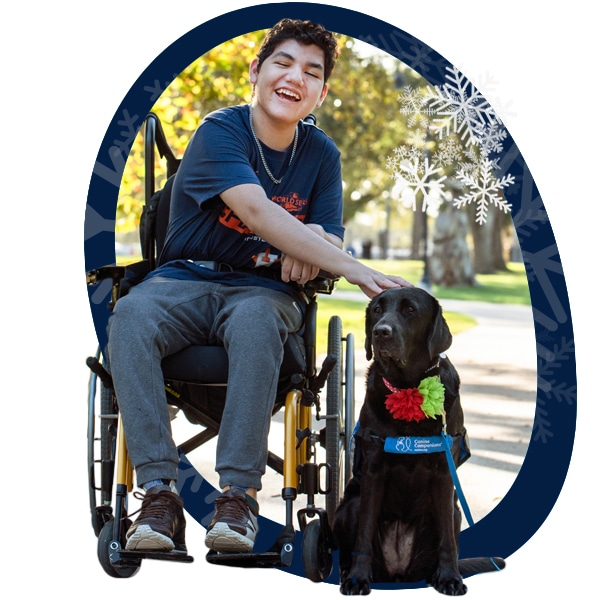 A blue circle with snowflakes around the image of a boy in a wheelchair petting his black lab service dog in a blue vest