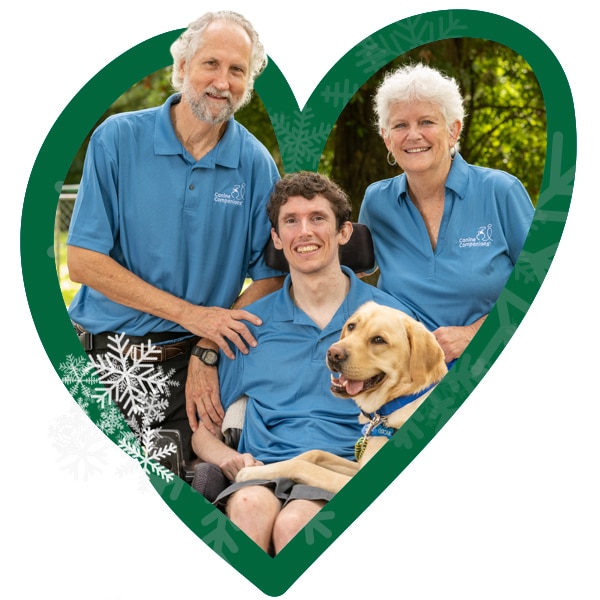 A green heart with snowflakes around the image of a boy in a wheelchair with his smiling parents behind him, and his yellow lab service dog laying across his lap
