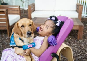Young girl with her service dog on her lap