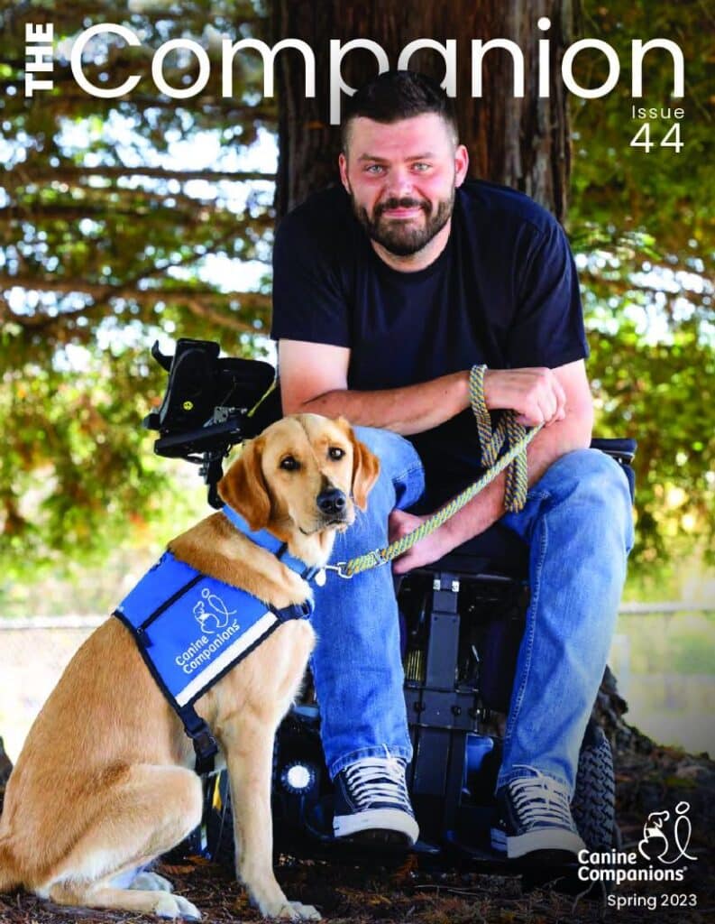 Cover of the Spring 2023 companion cover featuring a man in a wheelchair with a yellow lab service dog in a blue canine companions service vest sitting beside him, they are both looking at the camera confidently