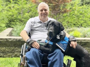 Man sitting in wheelchair with service dog.