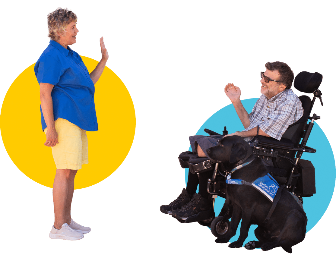 A woman waving to a man in a motorized wheelchair with a black lab service dog
