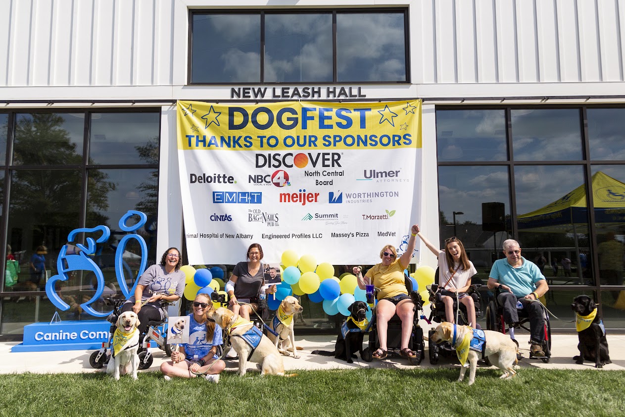 Dogfest participants in front of the sponsors' banner