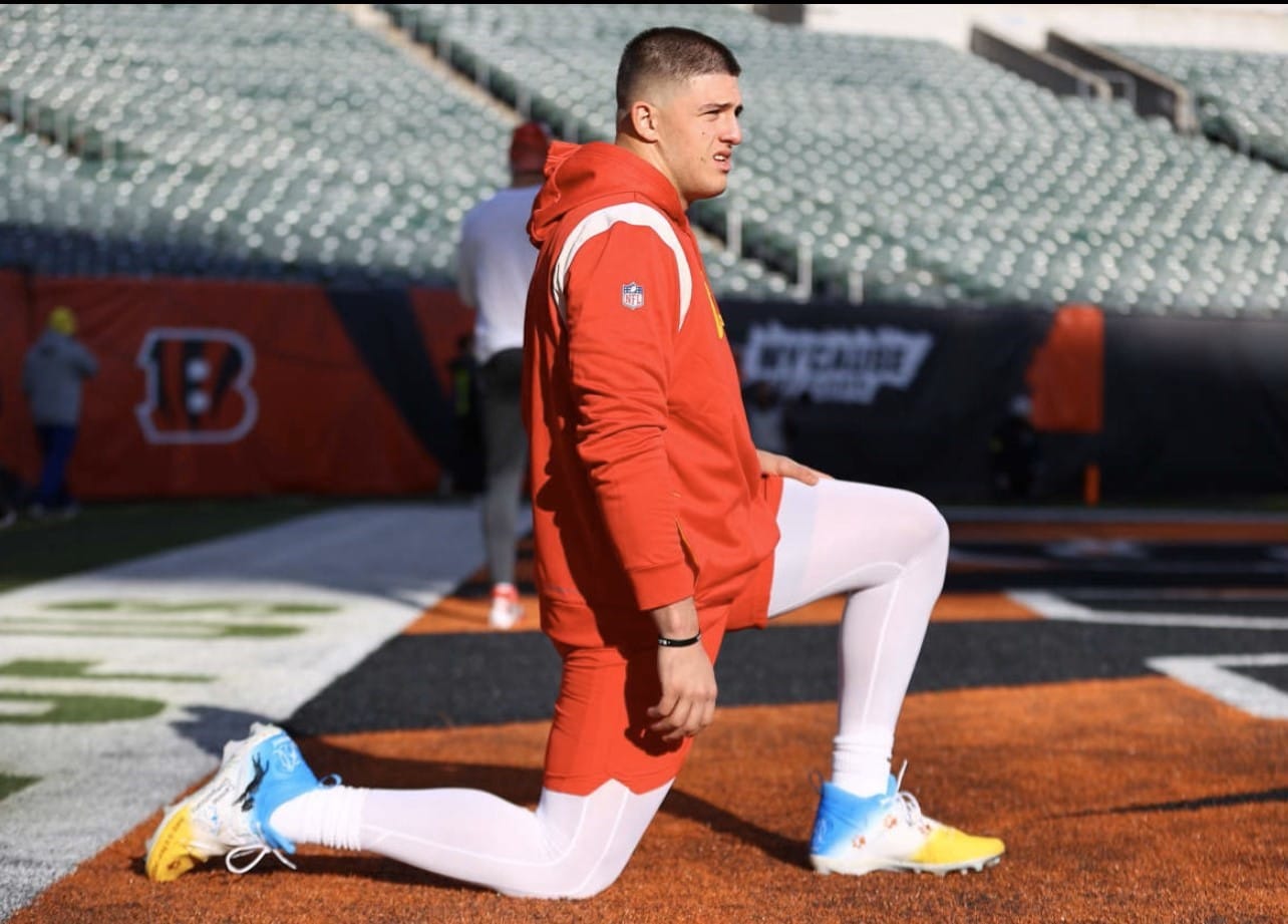 Chiefs Defensive End George Karlaftis poses in Canine Companions branded cleats. 