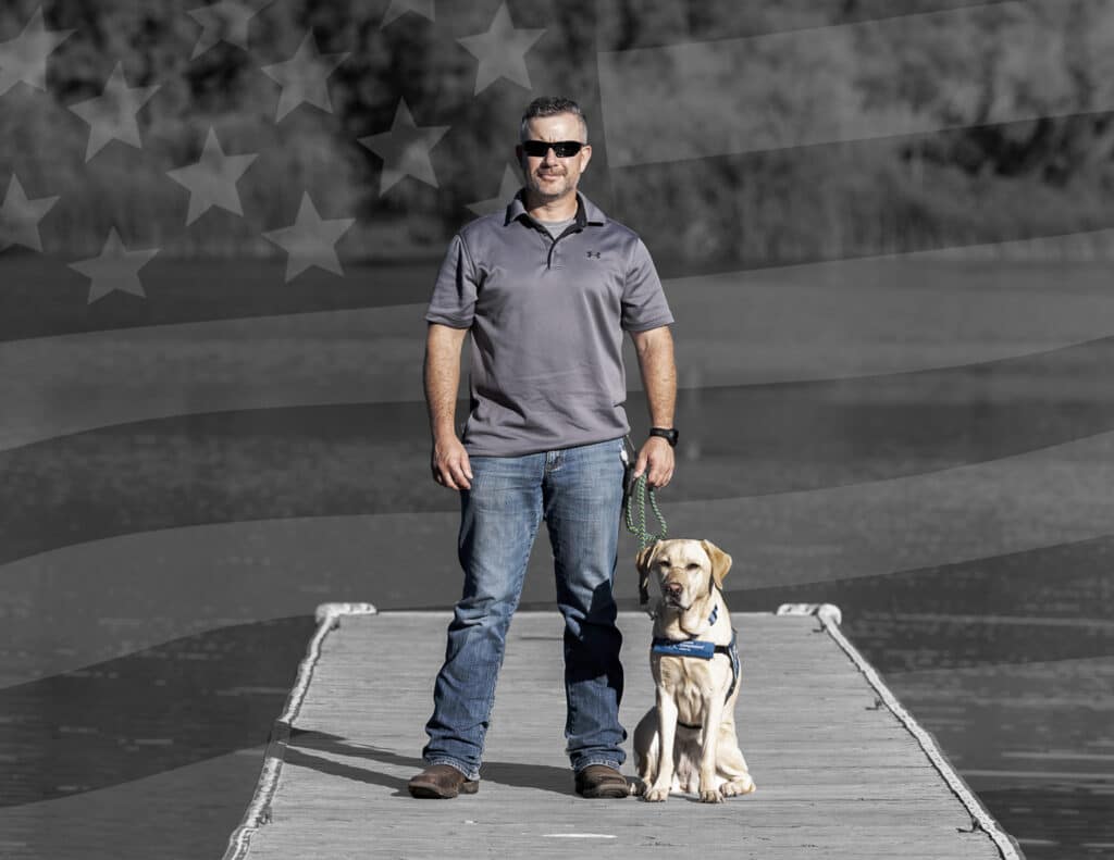 veteran man standing on a deck with service dog
