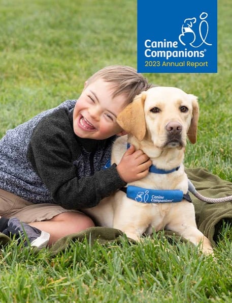 Cover of the Canine Companions 2023 Annual Report featuring the image of a young boy with a yellow lab service dog