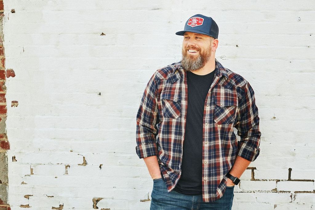 Scotty Hasting wearing a cap, standing in front of a white wall.