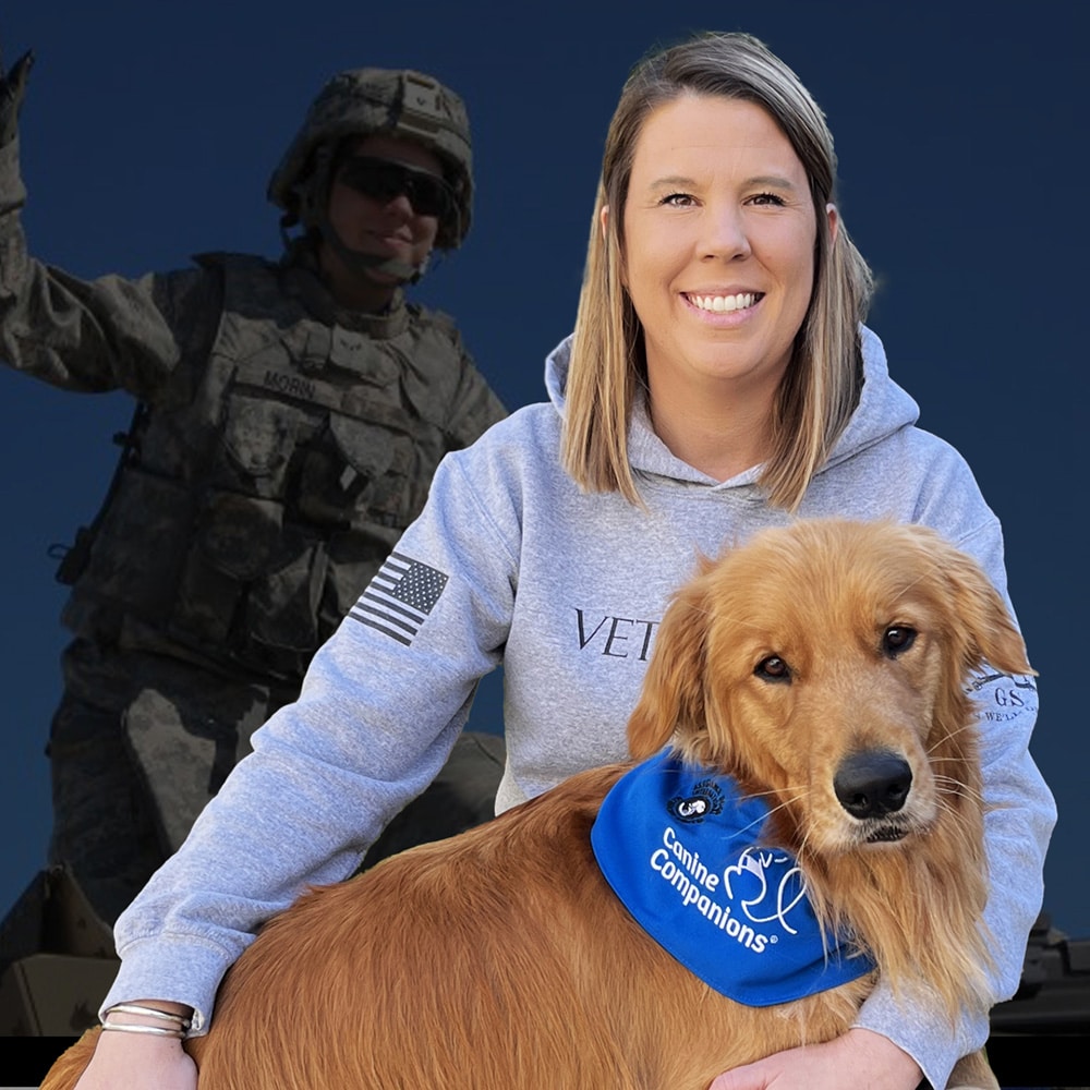 Smiling person wearing a hoodie with "VETERAN" text, holding a golden retriever with a "Canine Companions" bandana; a soldier in the background.