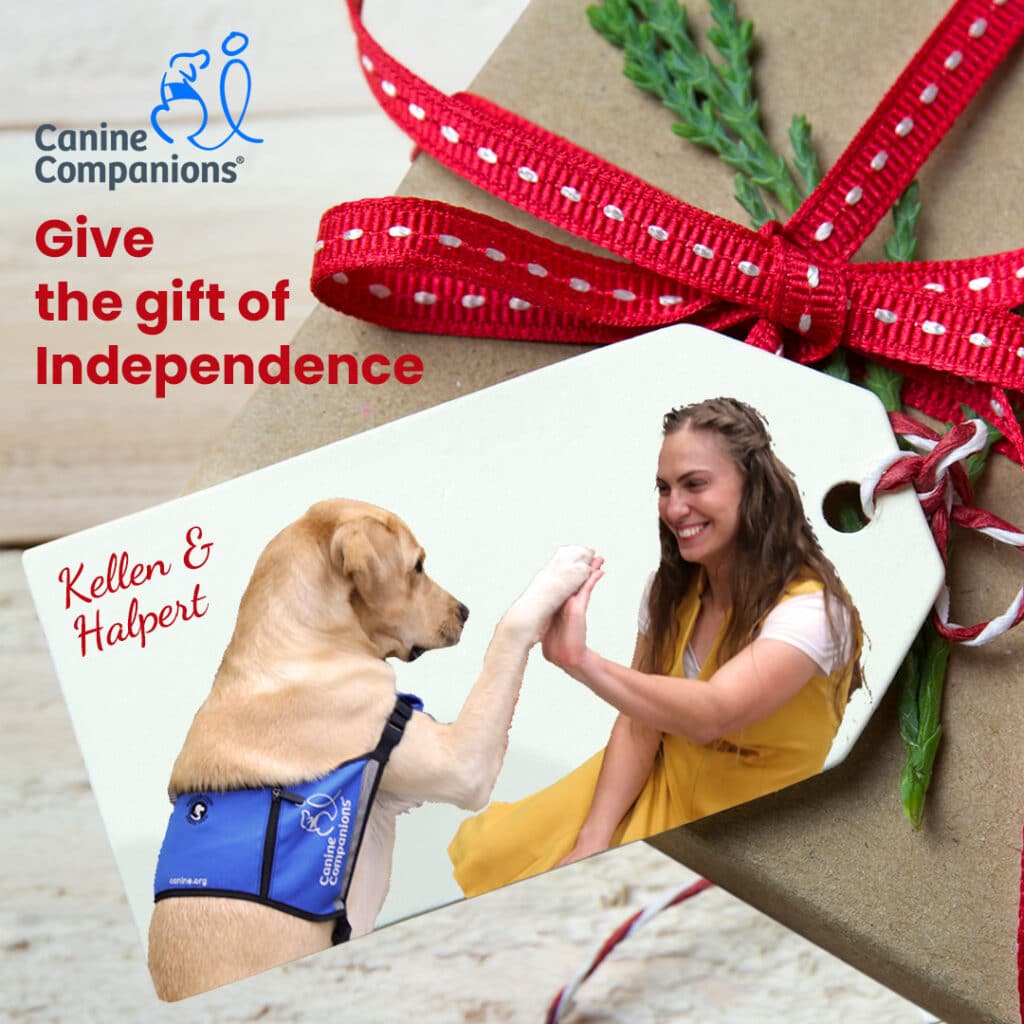 Service dog high-fiving a woman on a gift tag with red ribbon and greenery.