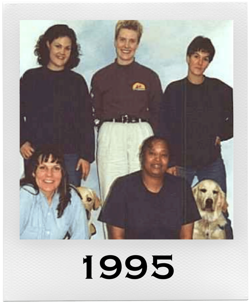 Group photo of five people and two dogs with "1995" written on the bottom.