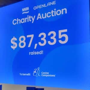 Large blue screen displaying "Charity Auction" and the total amount raised: "$87,335" along with "To benefit Canine Companions."