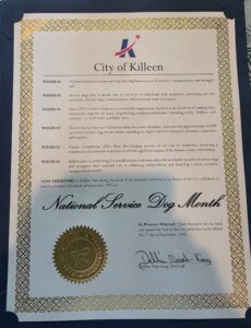 A proclamation document from the City of Killeen, adorned with a decorative gold border and the city seal, declaring September 2025 as National Service Dog Month. The text emphasizes the bond between humans and dogs, the importance of service dogs, and acknowledges the work of Canine Companions, signed by Mayor Debbie Nash-King.