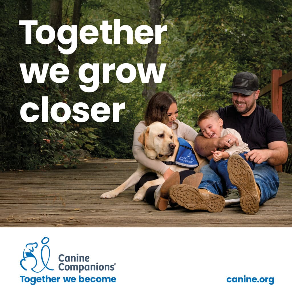 A family sitting on a wooden deck in a lush green park, enjoying time together with a Labrador retriever wearing a blue Canine Companions vest. The mother and father are smiling with their young son, who is laughing, as they all bond with the dog. Large text in the background reads, 'Together we grow closer.'