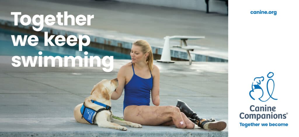 A woman with light brown hair sits on the edge of a swimming pool, wearing a blue swimsuit. She interacts with a yellow Labrador retriever wearing a blue service dog vest. The woman's legs show visible scars, and she has a prosthetic leg. In the background, there are poolside elements and text that reads, 'Together we keep swimming.'