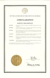 A proclamation document from the Governor of Georgia declaring September 2025 as Service Dog Month, highlighting the importance of service dogs for independence, and recognizing organizations that support people with disabilities. The document features the state seal and signatures from the Governor and Chief of Staff.