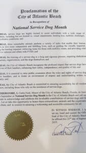 A proclamation from the City of Atlantic Beach recognizing September as National Service Dog Month, detailing the importance and roles of service dogs, signed by Mayor Curtis Ford with a gold municipal seal at the bottom.
