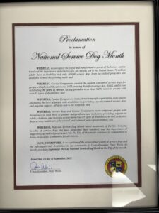 Framed proclamation honoring September 2025 as National Service Dog Month, recognizing the importance of service dogs for individuals with disabilities and acknowledging the efforts of Canine Companions and service dogs in promoting inclusivity and independence.