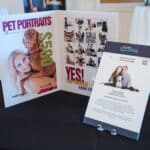 Auction display featuring pet portrait packages and photos of dogs with people