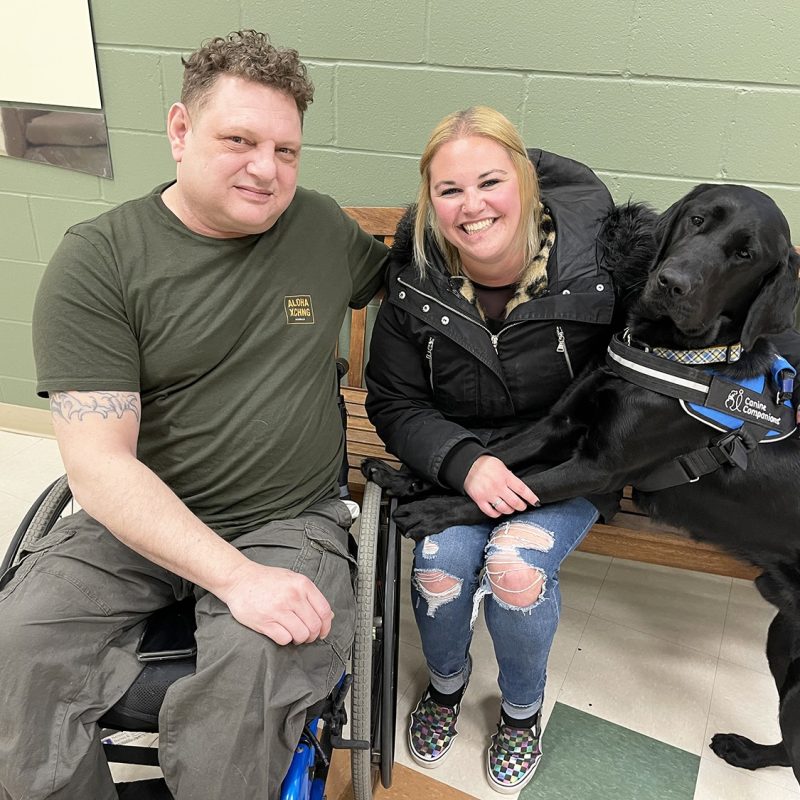 Man and woman sitting together with service dog